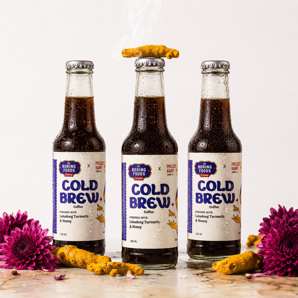 Three bottles of Turmeric Cold Brew coffee with fresh Lakadong turmeric root and flowers